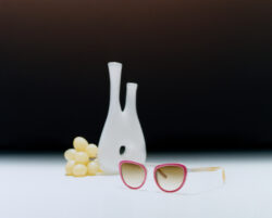 Eyeglasses placed in front of a vase.