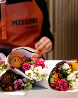 Floral bouquets served by someone wearing a Missoni apron.