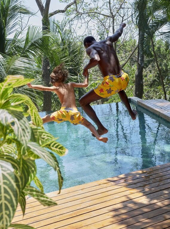 Jumping into water with Vilebrequin swimsuits.