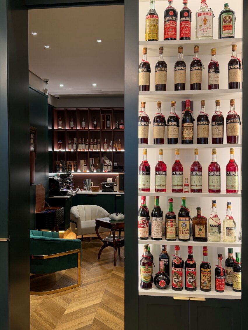 Interior of Collezione New York boutique showing seating and bottles of spirits.