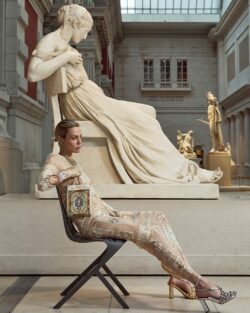 model sitting next to statue at The Met wearing Camilla dress