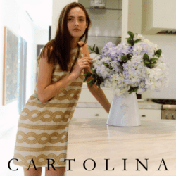 Model wearing Cartolina dress next to flowers