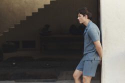 male model wearing blue Paige shorts and polo shhirt
