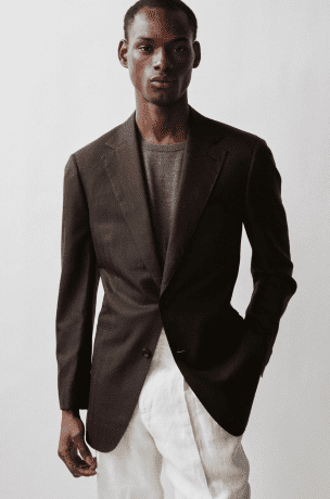 Male model wearing Thom Sweeney brown jscket and cream pants