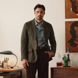 male model wearing denim shirt, olive jacket and jeans from Todd Snyder