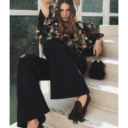 Model sitting wearing Ulla Johnson black pants and floral blouse