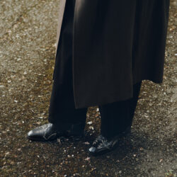 bottom half of male model weaing dark trousers, coat and Men's Jimmy Choo men's shoes