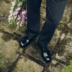 bottom half of male model weaing dark trousers, coat and Men's Jimmy Choo men's shoes