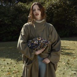 Model wearing Jimmy Choo green coat and multi color bag