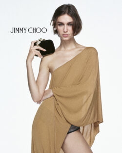 model earing tan dress and holding Jimmy Choo evening bag